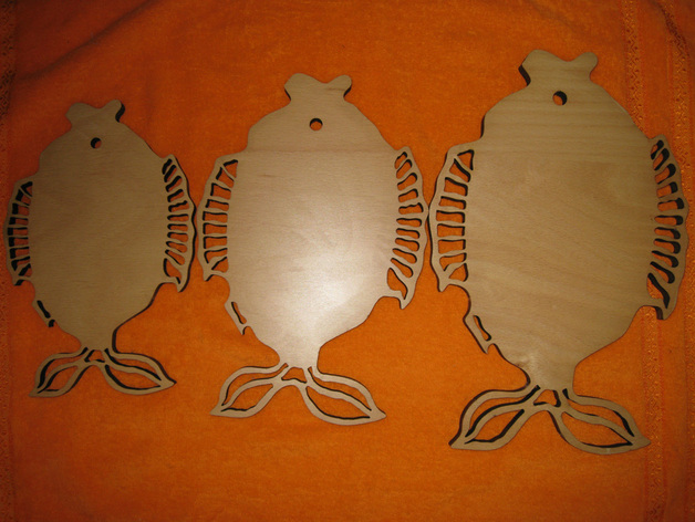 Three wooden fish-shaped boards with decorative fin cutouts