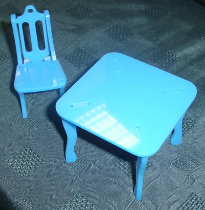 Blue miniature table and matching chair assembled from slotted flat parts