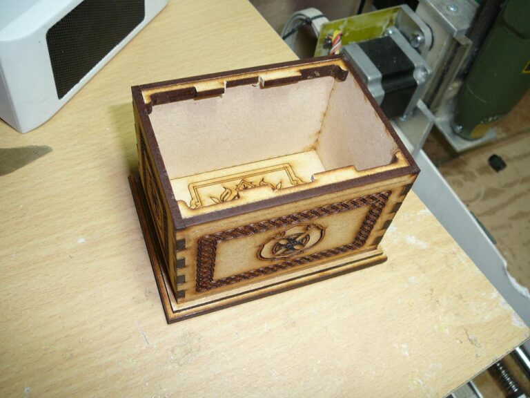 Small wooden box with finger joints and a shield emblem on the front
