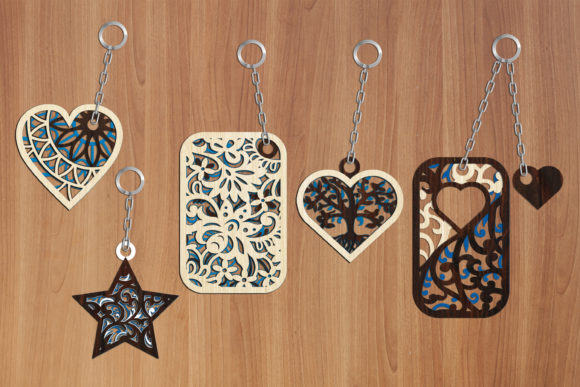 Five ornamental keychains including two hearts, a star, rectangle and curved shape