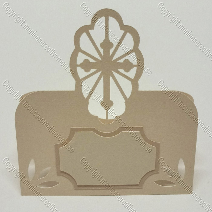 A place card with an oval flower-like crest and a framed blank name area