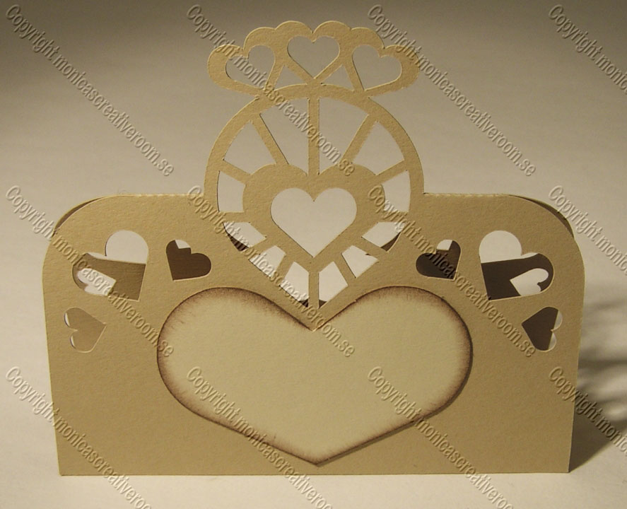Gold place card with three small top hearts and a heart-shaped central opening